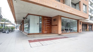 A modern building with a large glass entrance and a wooden door marked with the number 151. - 2-bedroom apartment in peaceful Providencia with AC and charm (Providencia)