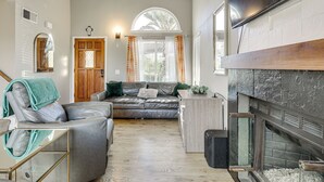 Ein Wohnzimmer mit Kamin, einer Couch, einem Couchtisch und einem Fernseher.