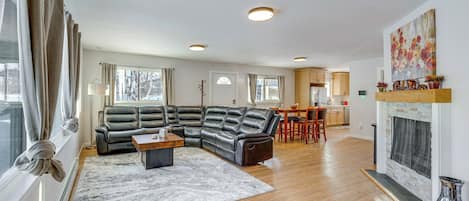 Una sala de estar moderna con un sofá modular, una mesa de centro y una chimenea.
