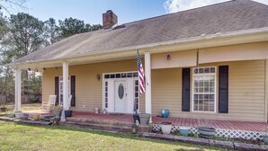 A two-story house with a front porch, a flag, and a mailbox. - Explore Gulf Coast & Beyond! Home w/ Yard & Games (Long Beach)