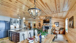 A wooden cabin interior with a kitchen, dining area, and living space.