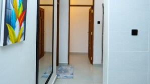 Ein Flur mit Spiegel, Tür und einem an der Wand befestigten Gerät.