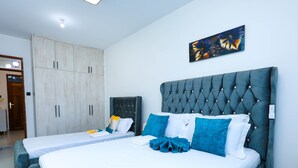 Ein Schlafzimmer mit zwei Betten, einem Kleiderschrank und einem Bild an der Wand.