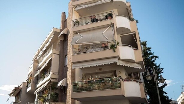 A multi-story residential building with balconies, some with railings and potted plants. - Cozy apartment in Sykies by MPS (Συκιές)