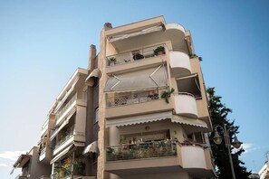 Un edificio residencial de varios pisos con balcones, algunos con barandillas y macetas.