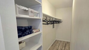 A narrow hallway with white shelving units, a coat rack, and a wooden floor. - Cozy 1-bedroom apartment in Downtown beautiful San Diego with AC (San Diego)
