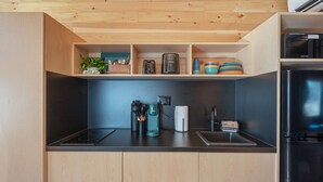 A modern kitchen with wooden cabinets, a black countertop, a built-in stove, and a microwave.