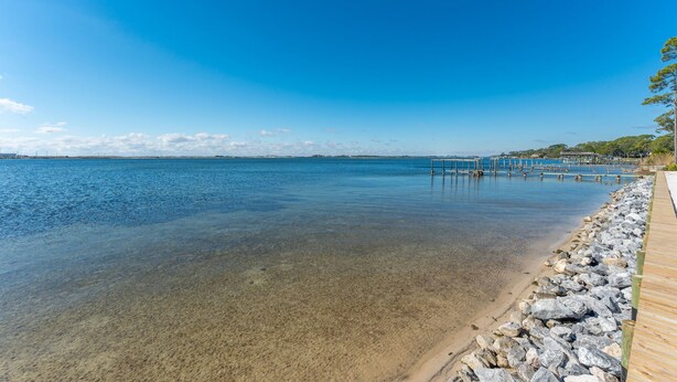 A clear waterfront view with a wooden dock extending into the water.