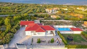 En bostadsfastighet med en swimmingpool, en uteplats och utsikt över det omgivande landskapet.
