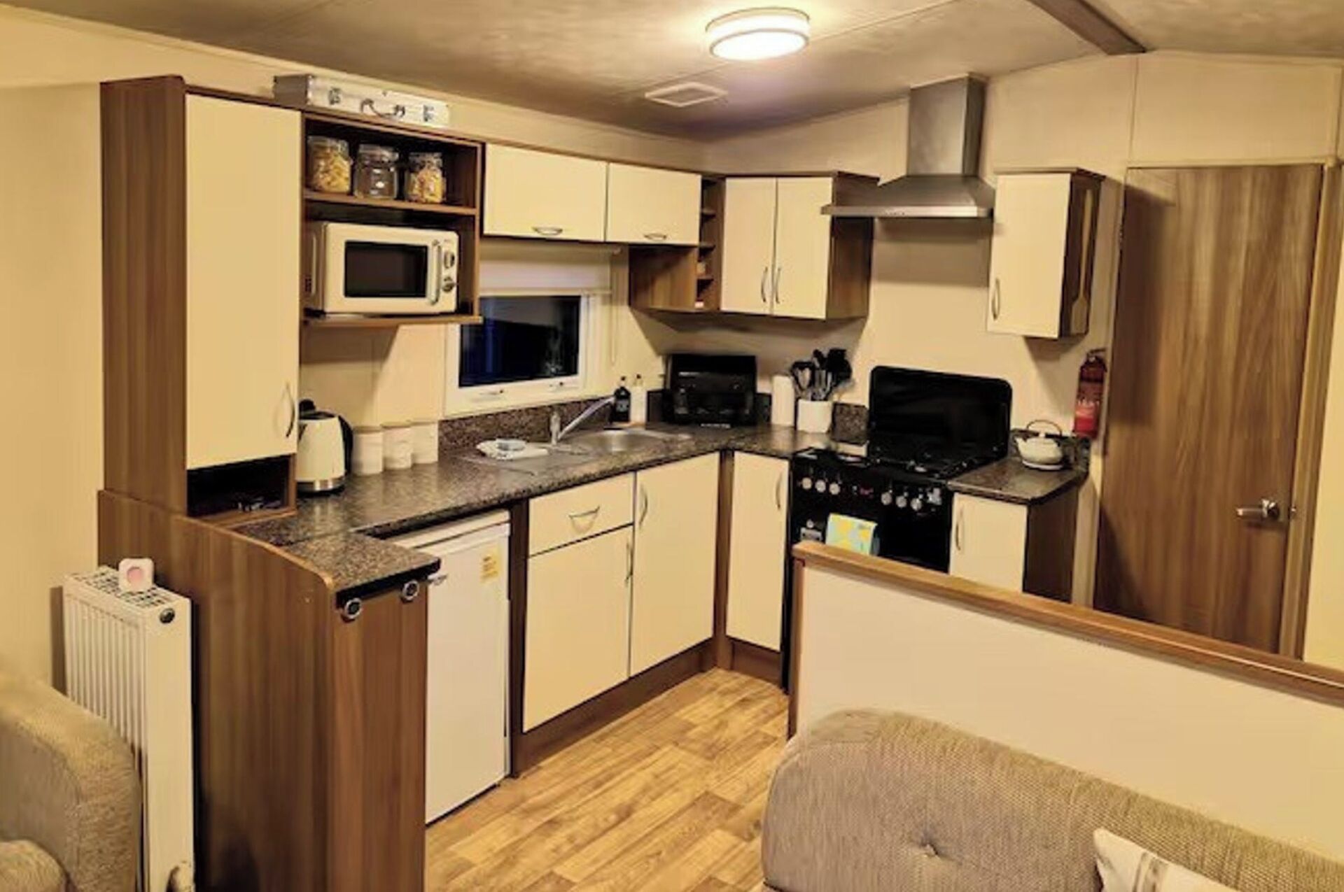 A compact kitchen with a microwave, stove, sink, and cabinets.