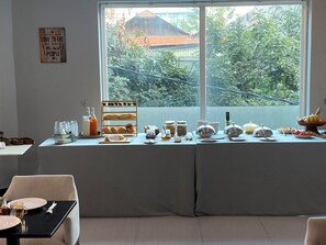 A breakfast setup with a table, chairs, and a window view. - Sai&su hotel (Phnom Penh)
