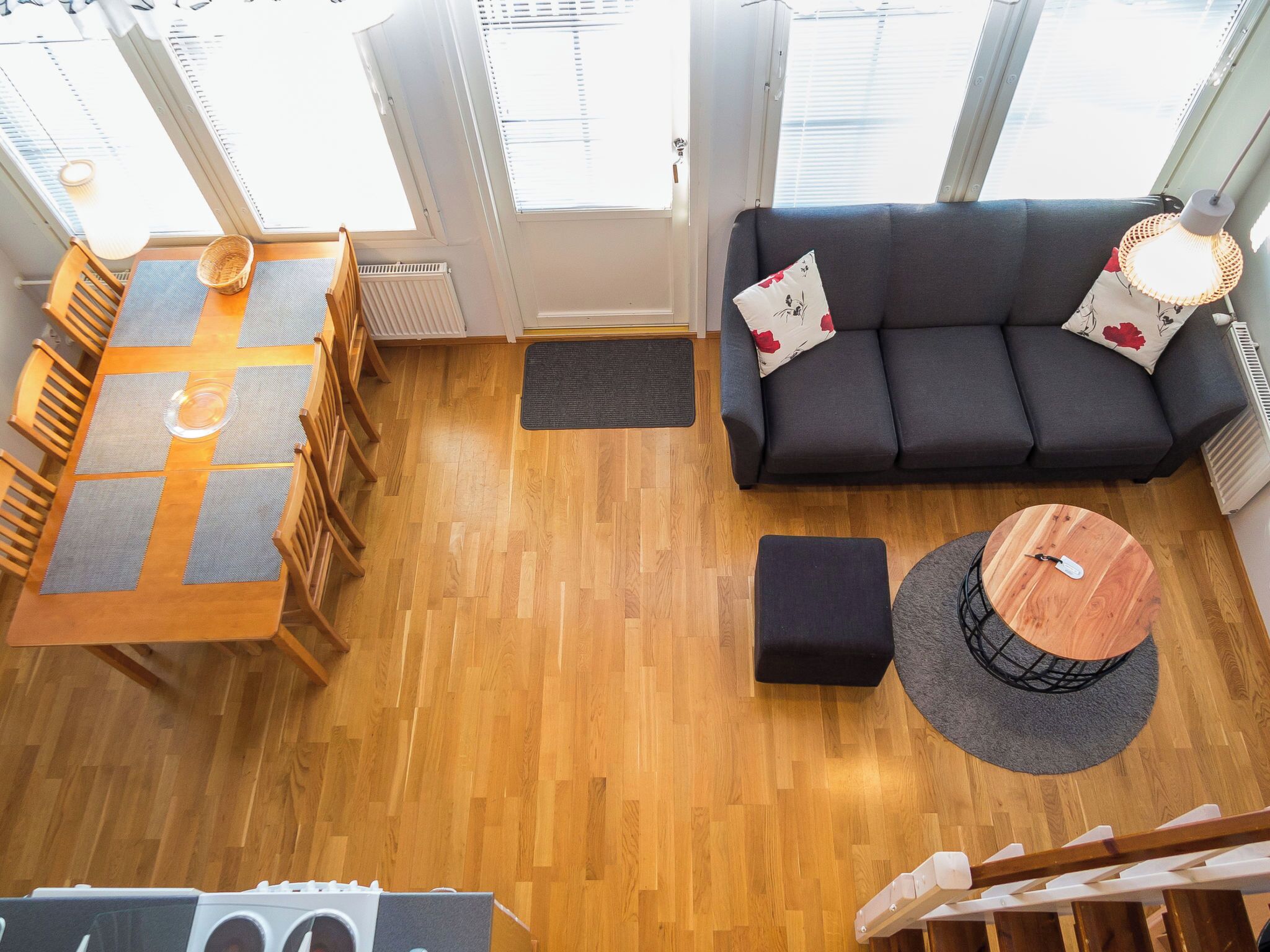 A modern living room with a sofa, a dining table with chairs, and a small coffee table.