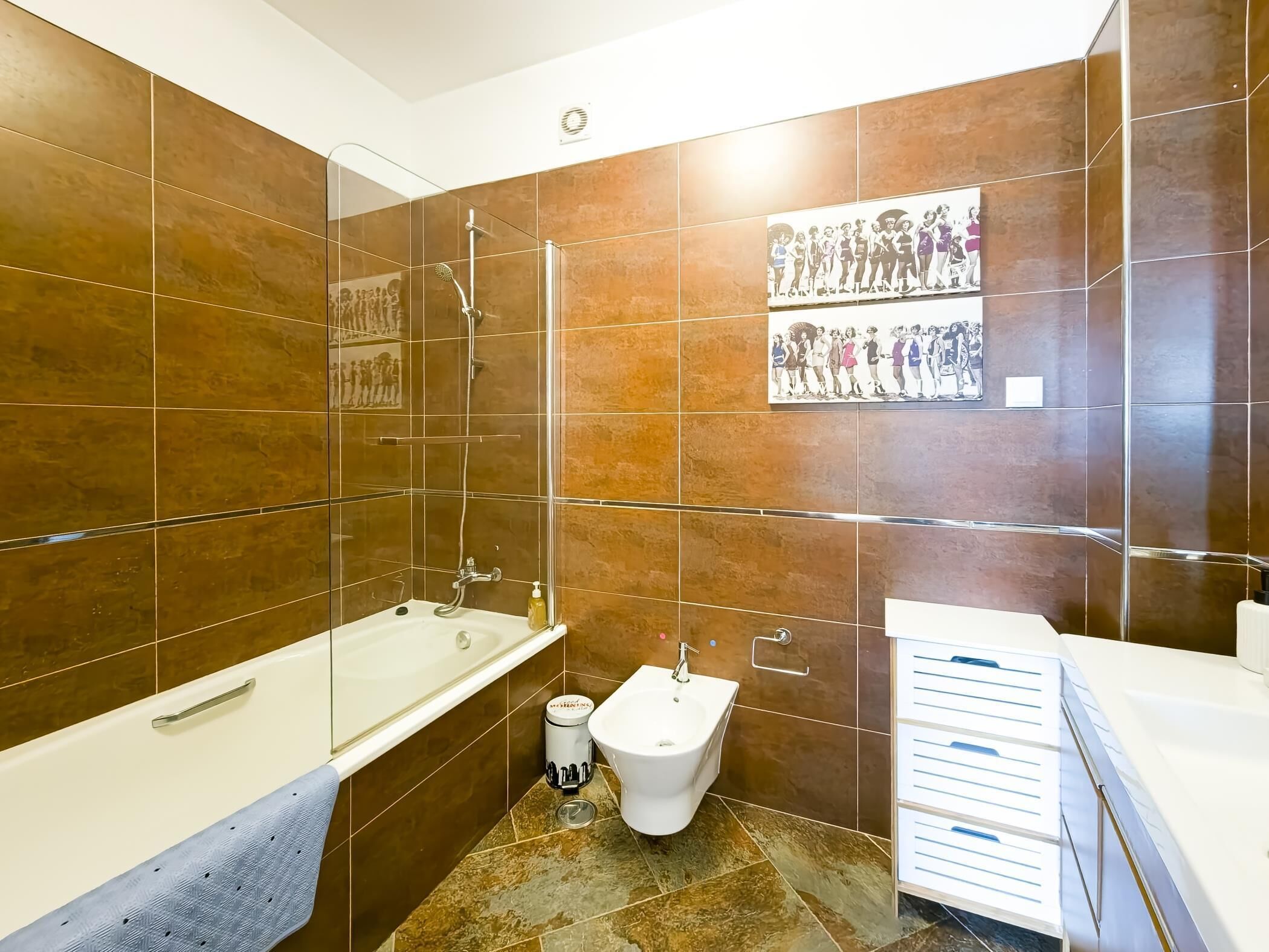 Une salle de bain moderne équipée d’une baignoire, d’une douche et d’un bidet.
