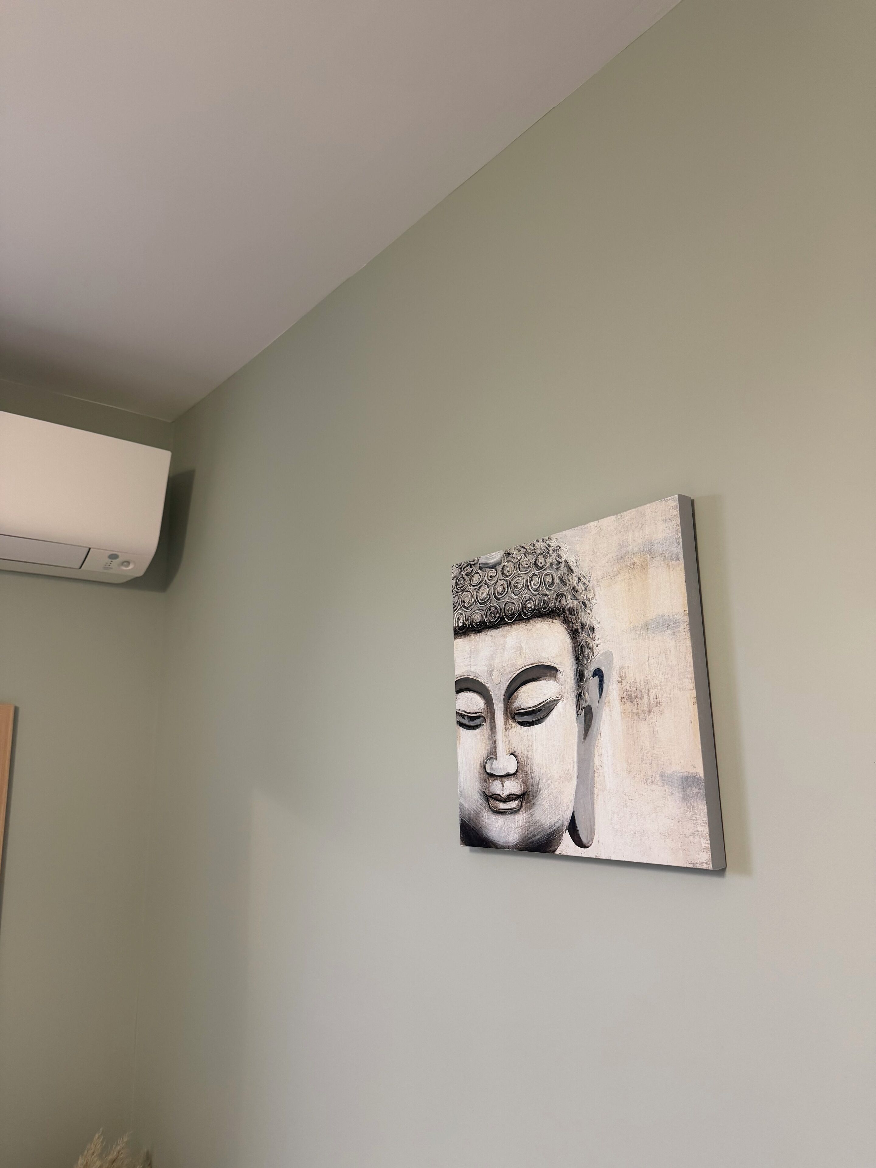 Una habitació amb aire condicionat fixat a la paret i un quadre abstracte gran.