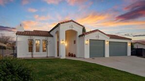 A modern two-story house with a garage, a well-maintained lawn, and a sunset sky. - Paso del Sol |Pool Table, fire pit (Paso Robles)