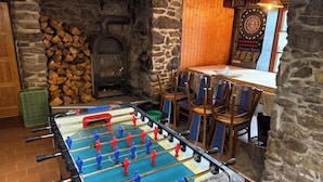 A room with a foosball table, a dartboard, and a fireplace. - Hotel Na Pastvinách (Tremesne)