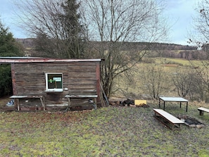A rustic wooden cabin with a window and a bench outside.