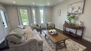 A living room with a gray sofa, a wooden coffee table, and a patterned rug.