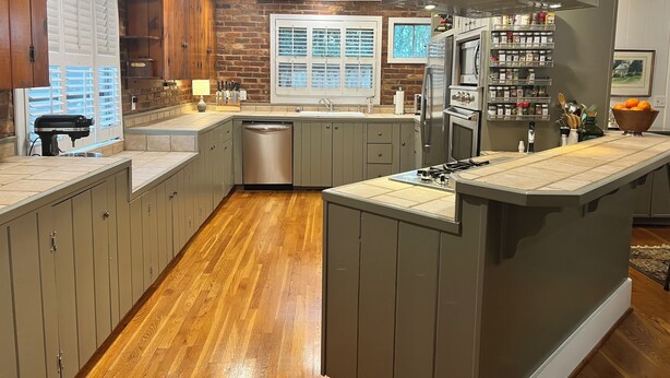 Una cocina moderna con armarios de madera, horno empotrado y un ventanal grande.