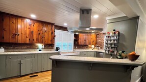 Una cocina moderna con armarios de madera, una isla central y un especiero empotrado.