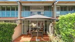 Ein zweistöckiges Haus mit überdachter Veranda, Essbereich und sichtbarer Treppe.