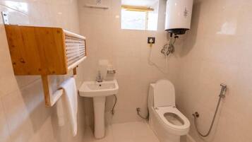 Un baño con inodoro, lavamanos y ducha.