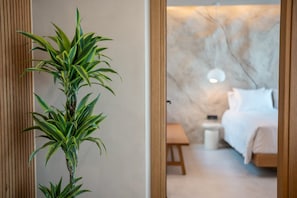 Une chambre à coucher moderne avec un lit, une table de chevet et une petite plante en pot.