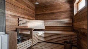 A sauna with wooden benches and a small table, a window, and a heater. - Nice house with relaxed athmosphere (Uusimaa)