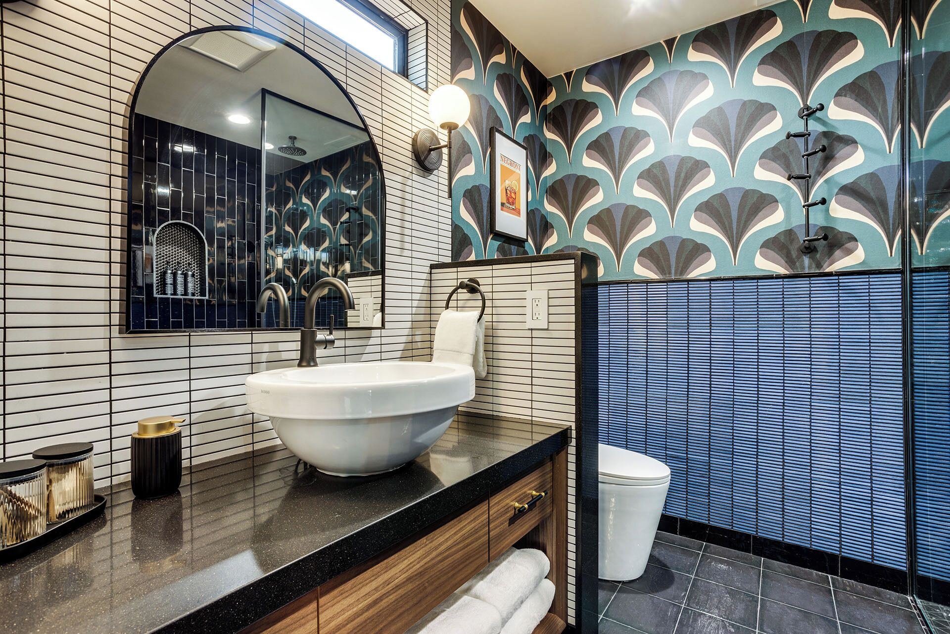 Un baño moderno con un lavamanos grande, un espejo, una ducha y azulejos decorativos.