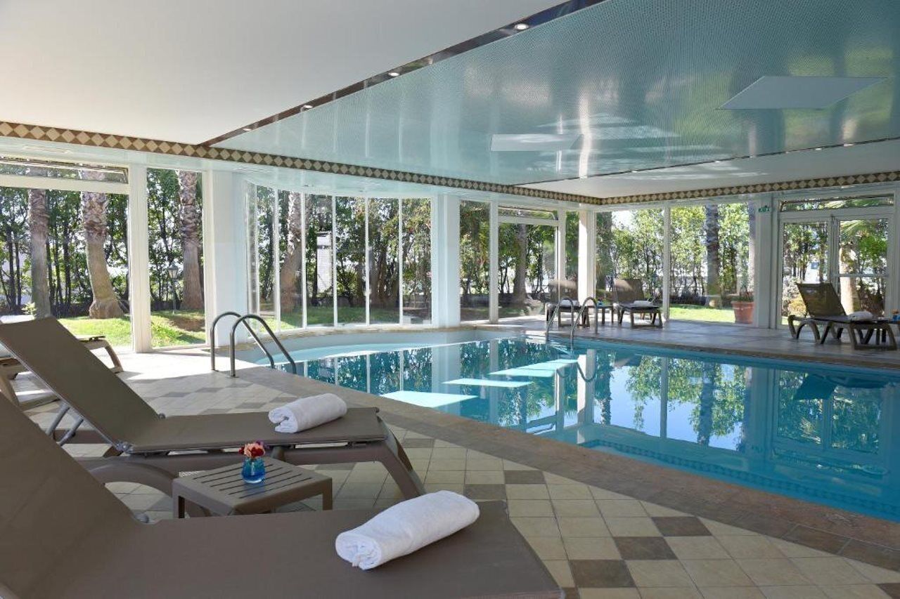 Un espace piscine avec des chaises longues et un coin salon abrité.