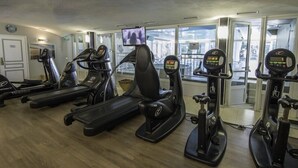 Ein Fitnessstudio mit mehreren Laufbändern, Ergometer und einem Bildschirm.