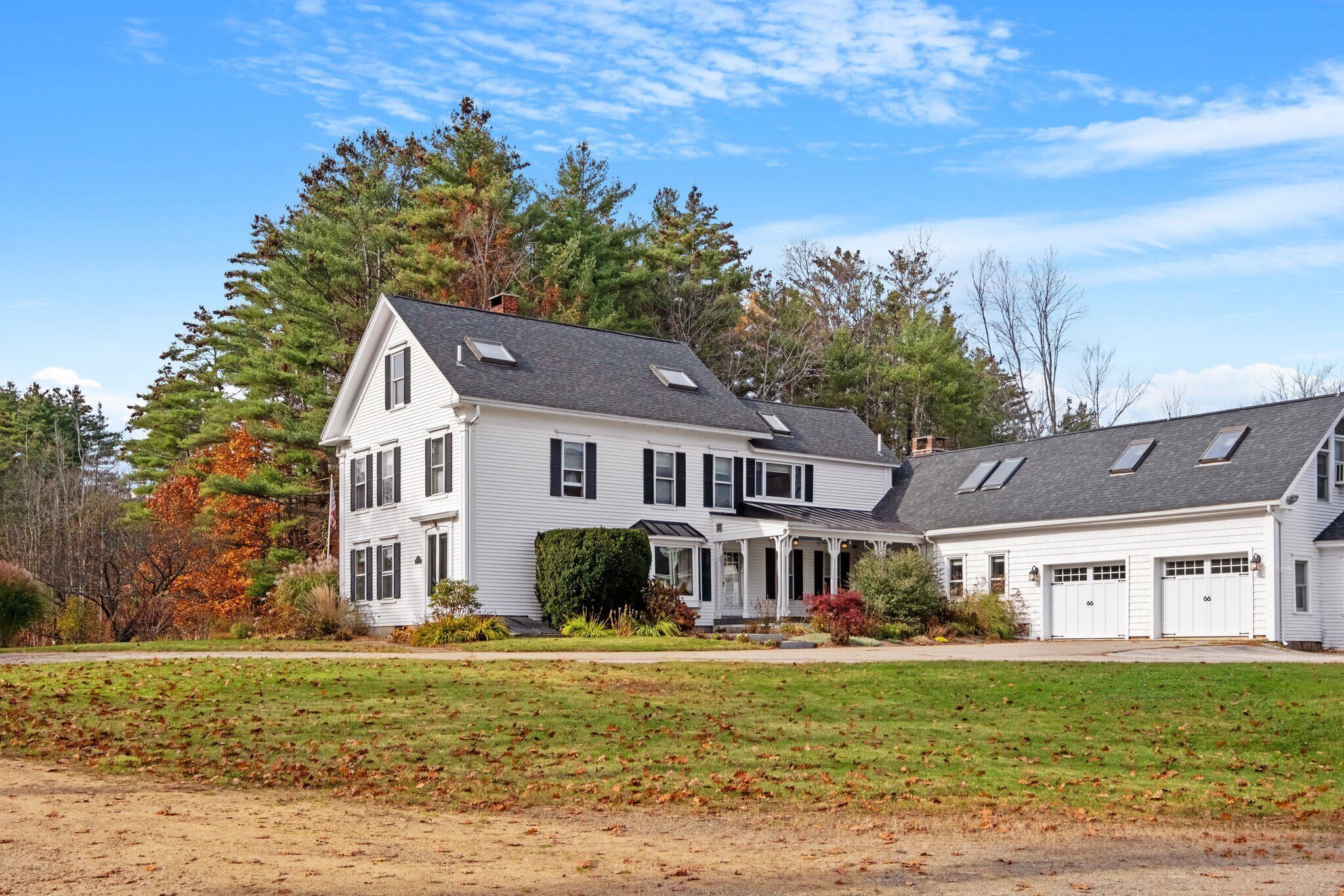 The farmhouse and garage in autumn, with the skylights of the loft visible on the roofline and the grounds looking their best.