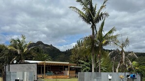 A building with a corrugated metal exterior, a covered porch, and a satellite dish.