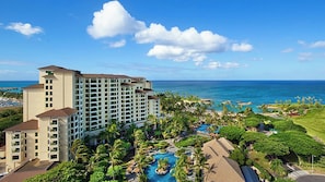 Ein Resort mit mehreren Gebäuden, einem großen Poolbereich und Blick auf den Ozean.