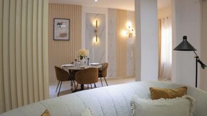 A modern hotel room with a bed, a dining area with a table and chairs, and a lamp. - Luxurious 1-bedroom apartment & 1 African-style bedroom (Dakar)