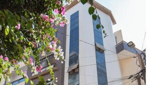 A multi-story residential building with a modern design, featuring large windows and balconies. - Luxurious 1-bedroom apartment & 1 African-style bedroom (Dakar)