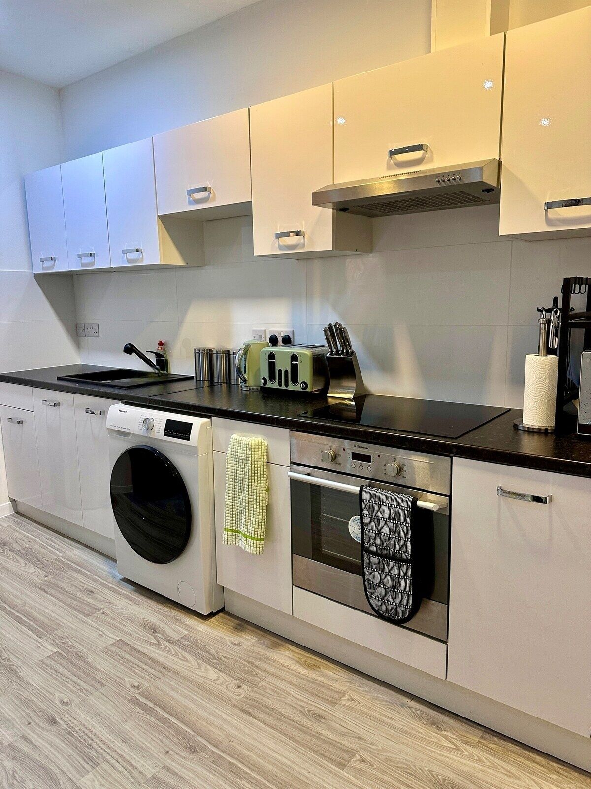 A modern kitchen with a built-in washer and dryer, a stove, oven, and a toaster.