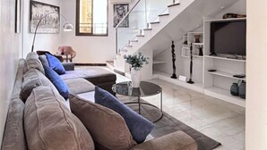 Ein modernes Wohnzimmer mit einer Couch, einem Couchtisch und einer Treppe.