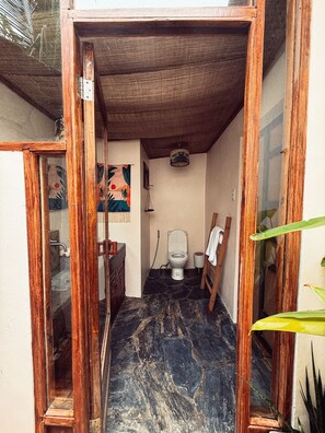 Ein kleines Badezimmer mit Toilette, Waschbecken und Spiegel.