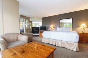 Ein Hotelzimmer mit Bett, Fernseher, Sofa und Holztisch.