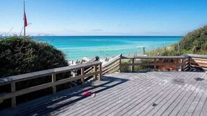 A wooden deck with a railing overlooking a beach. - Blu’s Away - Short Walk to the Beach! Just steps from the Pool! Rooftop Deck with beautiful views! Sleeps 12 (Santa Rosa Beach)