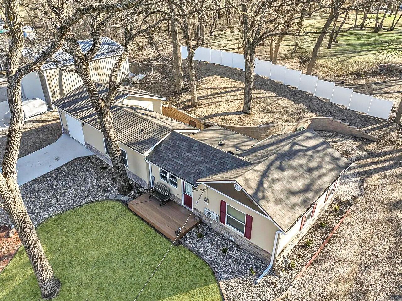 Een gelijkvloers huis met een overdekte patio, een klein terras en een omheinde tuin.