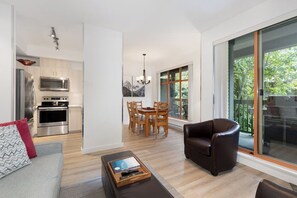 A modern living space with a kitchen, dining area, and seating area.