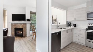 Una cocina moderna con armarios blancos, horno integrado y lavavajillas.