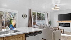 A modern kitchen with a dishwasher, a sink, and a window overlooking a backyard. - Nampa`s New Nest - The Orion (Nampa)
