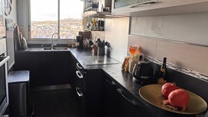 A modern kitchen with a large window, a sink, and a stove. - Lovely 3-room apartment with swimming pool in Puteaux (Puteaux)