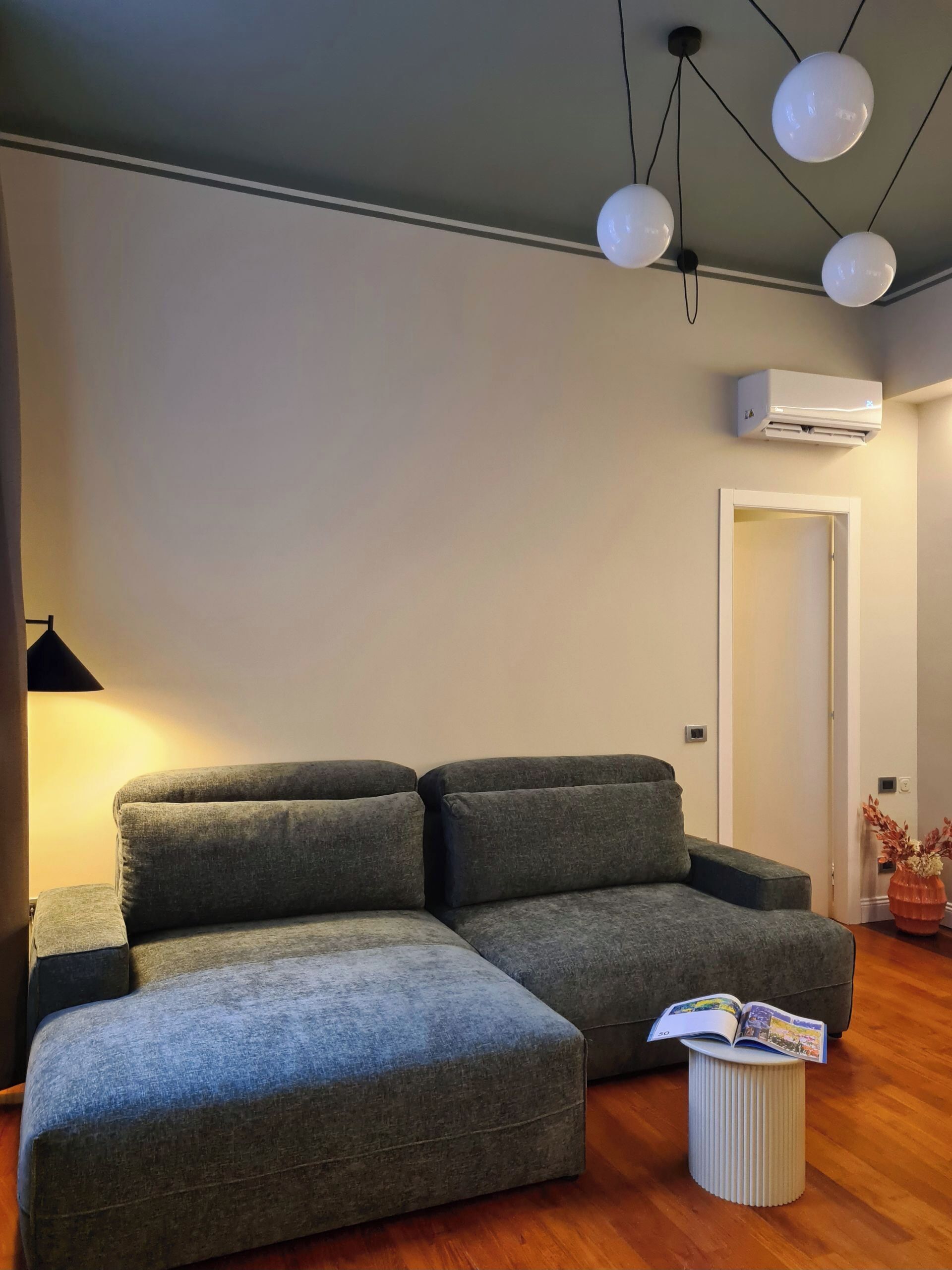 Een moderne woonkamer met een modulaire bank, een klein bijzettafeltje en een boek.
