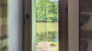 A view through a door with a stone wall and a wooden door handle. - Private island in Berry - Riverside paradise (Le Menoux)