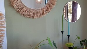 A room with a round mirror, a woven wall hanging, and several potted plants on a marble countertop. - Cozy cottage, mountain view - 4 guests (Le Tampon)