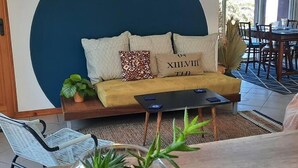 A cozy seating area with a sofa, cushions, and a coffee table. - Cozy cottage, mountain view - 4 guests (Le Tampon)
